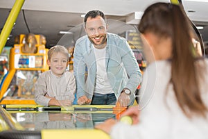 happy father with adorable little kids playing air hockey