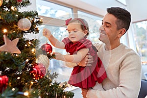 happy father and baby girl decorate christmas tree