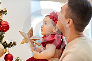 happy father and baby girl decorate christmas tree