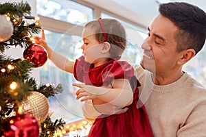 happy father and baby girl decorate christmas tree