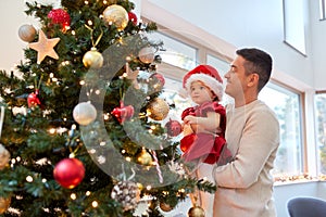 happy father and baby girl decorate christmas tree