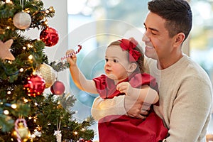 happy father and baby girl decorate christmas tree