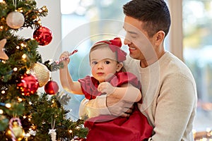 happy father and baby girl decorate christmas tree