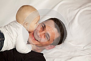 Happy father being kissed by his baby girl photo