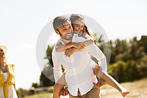 Happy Father Carrying Daughter Going On Family Picnic In Countryside