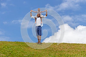 Happy father carrying daughter on shoulders, Cheerful african american girl on the shoulders of his father