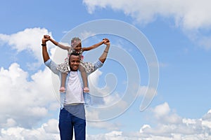 Happy father carrying daughter on shoulders, Cheerful african american girl on the shoulders of his father with clipping path