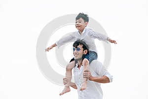 Happy father carrying his son on the neck.