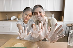 Happy father and cheerful daughter kid having fun while baking