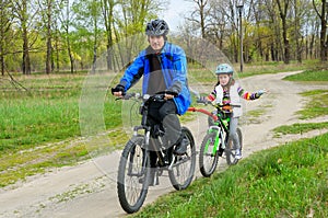 Happy father and child on bikes, family cycling