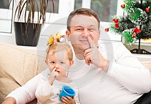 Happy father and child girl hugging and picking his nose