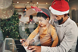 Happy father, child and piano for christmas celebration, songs and xmas hymn at home. Parent, boy kid and teaching