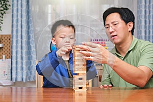 Happy father and cute little Asian toddler boy child excited with Jenga game, Dad and son spending quality time together at home
