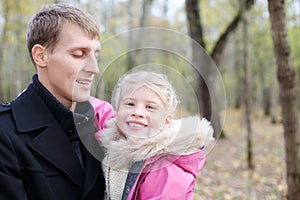 Happy father and daughter in autumn forest.