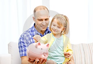 Happy father and daughter with big piggy bank