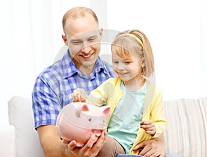 Happy father and daughter with big piggy bank