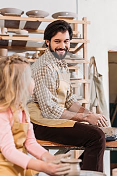 happy father and daughter making ceramic pot