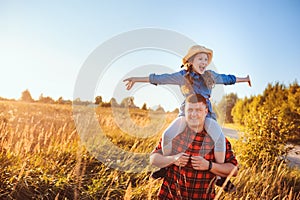 Happy father and daughter walking on summer meadow, having fun and playing.