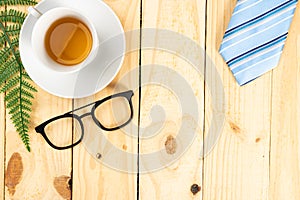 Happy Father Day background concept with blue necktie, glasses and cup of tea on wooden background with copy space for text