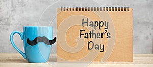 Happy Father day with paper notepad, Blue coffee cup or tea mug and Black mustache decor on table. International men day and