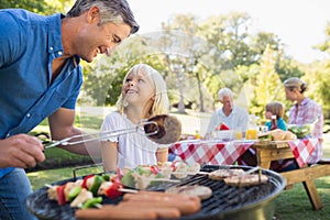 Happy father doing barbecue with her daughter