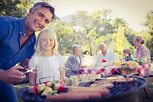 Happy father doing barbecue with her daughter