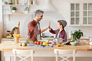 Happy father give five to loving son on kitchen