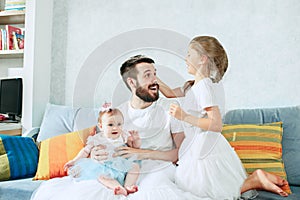 The happy father and his baby daughters at home