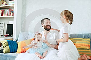 The happy father and his baby daughters at home