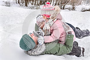 A happy father with his children playing in the snow in the open air