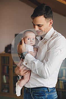 Happy father with his newborn daughter in his house.