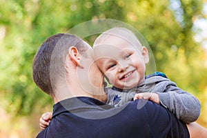 Happy father and his son outdoors. Child hugging daddy.