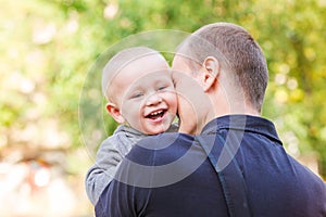 Happy father and his son outdoors. Child hugging daddy.