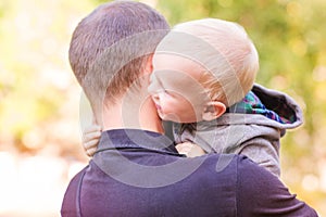 Happy father and his son outdoors. Child hugging daddy.