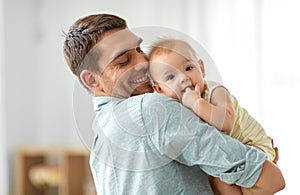 Happy father holding little baby daughter at home