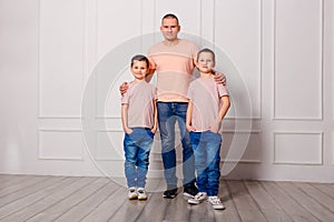 Happy father hugs two sons in jeans