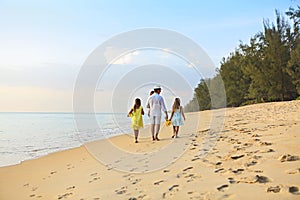 Happy father with kids have fun on beach walking at sunset