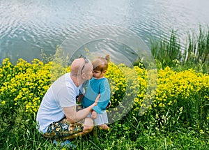 Happy father kissing baby daughter outdoors