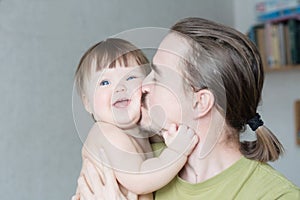 Happy father kissing baby daughter portrait. Happiness in simple lifestyle. Handsome bearded young man holding infant