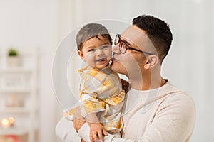 Happy father kissing little baby daughter at home