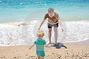 Happy father and little baby son having fun at beach vacation