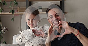 Happy father and little daughter making with fingers heart shape