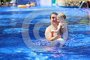 Happy father with little daughter in swimming pool