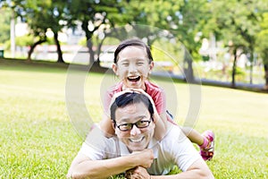 Happy father and little girl lying on the grass