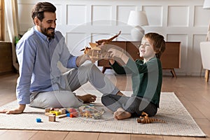 Happy father and little son having fun with toys together