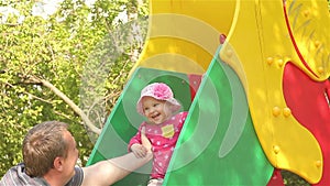 Happy father playing with baby girl on the playground
