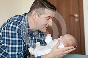 Happy father playing with little baby at home. Family, fatherhood concept