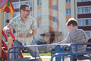 Happy father playing with little boy on the Playground