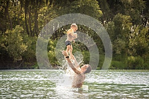 Happy father playing son kid throw up swimming lifestyle portrait concept happy paternity and childhood during summer countryside