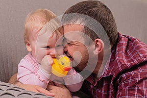 Happy father plays with little daughter, close-up